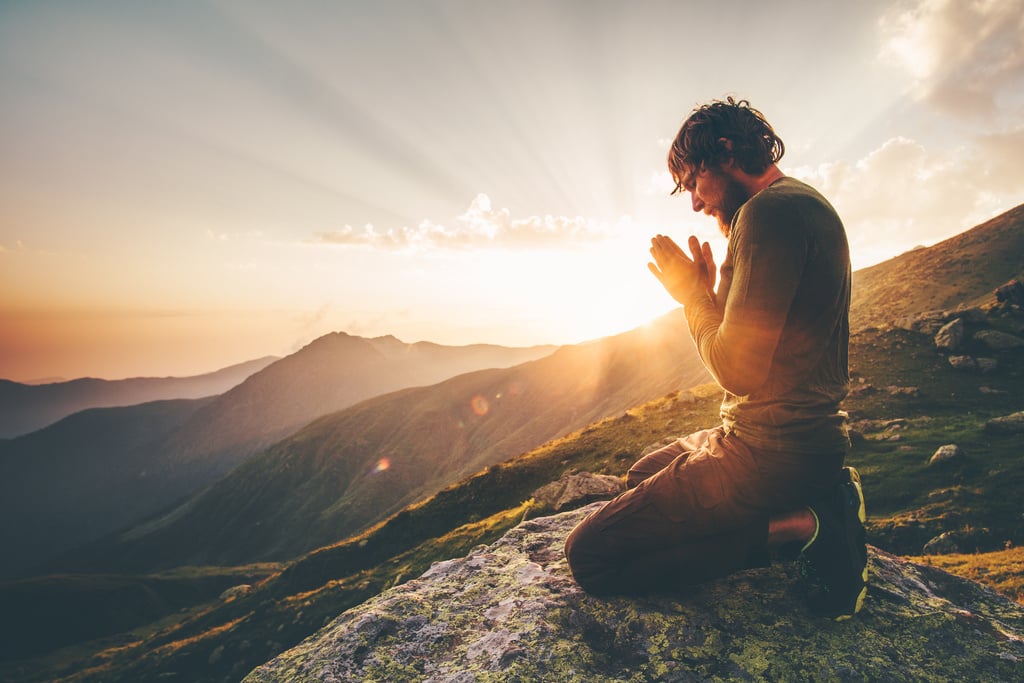 Man praying at sunset mountains Travel Lifestyle spiritual relaxation emotional concept vacations outdoor harmony with nature landscape